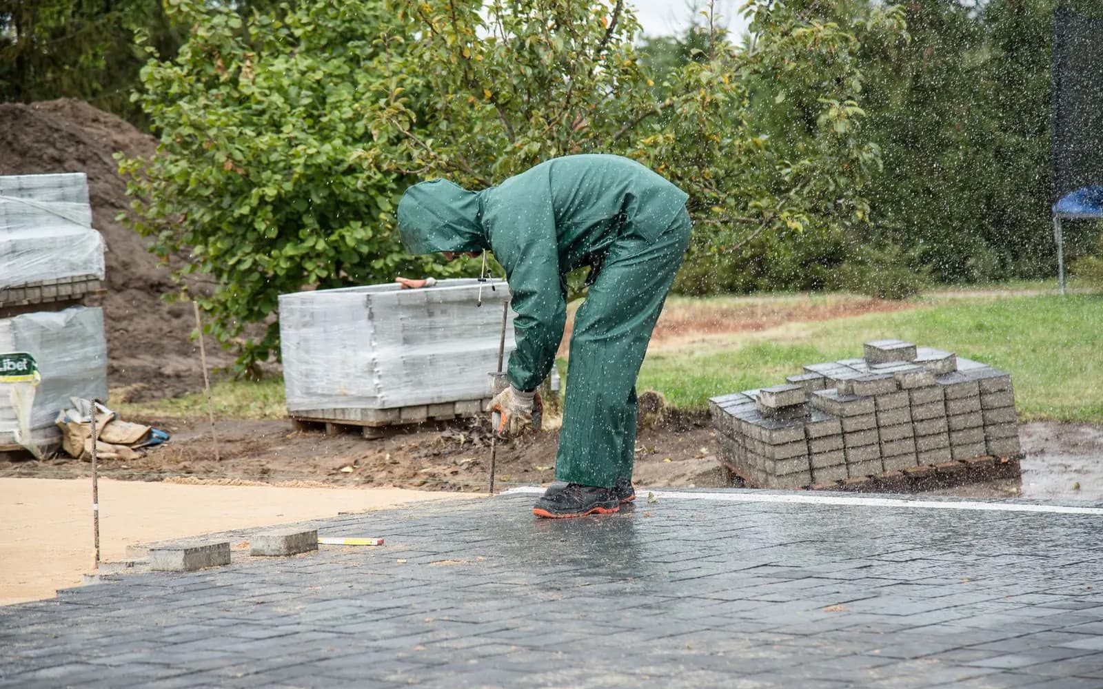 Paving blocks being installed across a compacted and levelled sub-base